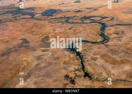 Delta de l'Okavango, aérienne, magnifique paysage coloré sec avec rivière bleu foncé et orange Savanna Banque D'Images