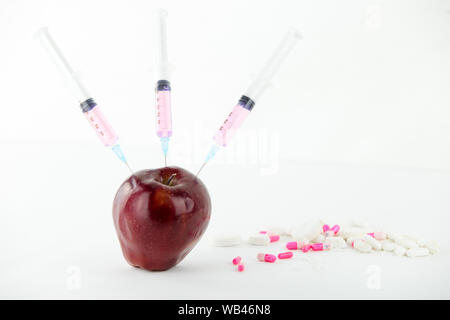 Concept : les droits de l'OGM, manipulation de nature et des fruits empoisonnés. Close-up d'une pomme contaminés par la seringue trois médicaments et en fileté Banque D'Images