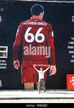 Liverpool. UK.24 août 2019 ; Anfield, Liverpool, Merseyside, Angleterre, Premier League anglaise de football, Liverpool et Arsenal Football Club ; un ventilateur pose pour une photo en face de la fresque géante de trente Alexander-Arnold de Liverpool peint sur le côté de la maison près du stade - strictement usage éditorial uniquement. Pas d'utilisation non autorisée avec l'audio, vidéo, données, listes de luminaire, club ou la Ligue de logos ou services 'live'. En ligne De-match utilisation limitée à 120 images, aucune émulation. Aucune utilisation de pari, de jeux ou d'un club ou la ligue/player Crédit : publications Plus Sport Action Images/Alamy Li : Action Crédit Banque D'Images