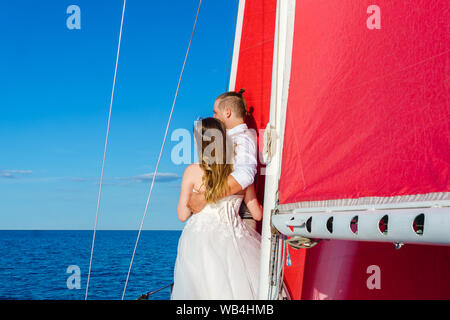 Jeunes mariés dans un voyage de noces à la mer sur un yacht à voile Banque D'Images