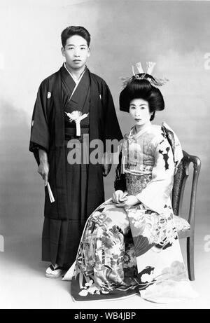 [ 1930 Japon - Japonais mariés ] - portrait de mariage avec les deux époux et épouse portant des vêtements de style traditionnel. 20e siècle Tirage argentique d'époque. Banque D'Images