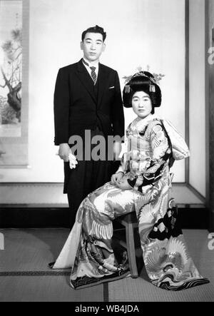 [ 1930 Japon - Japonais mariés ] - Par les années 1920, les coutumes de mariage japonais a subi une grande transformation en raison de l'influence occidentale. C'est visible dans ce beau portrait de mariage où le marié porte un costume de l'Ouest, tandis que l'épouse, c'est vêtu d'un Kimono de mariage décoré magnifiquement. 20e siècle Tirage argentique d'époque. Banque D'Images