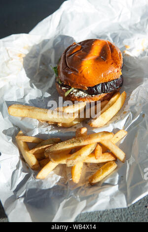 Délicieux hamburger veggie d'aubergines maison avec frites sur fond de papier blanc. Plats végétariens et végétaliens Banque D'Images