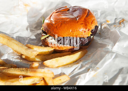 Délicieux hamburger veggie d'aubergines maison avec frites sur fond de papier blanc. Plats végétariens et végétaliens Banque D'Images