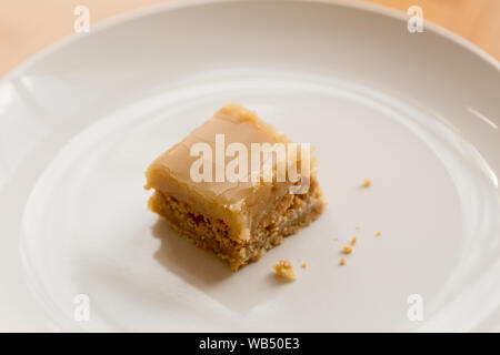 Un morceau de carré de caramel sur une assiette blanche avec chapelure Banque D'Images