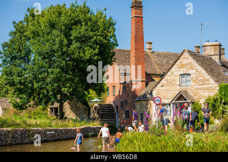 Les enfants pagayer dans le fleuve, Lower Slaughter, Cotswolds, Royaume-Uni. Banque D'Images