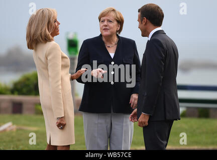 Le président français, Emmanuel Macron et sa femme Brigitte salue la chancelière allemande, Angela Merkel (centre), à l'accueil officiel durant le sommet du G7 à Biarritz, France. Banque D'Images