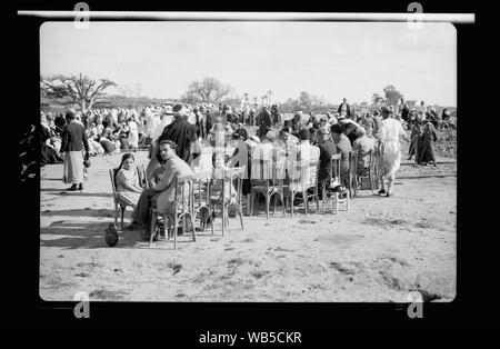 Fin d'une querelle à el Hamani Village près de Mejdal le 20 avril '43. Les invités étaient assis à table, tandis que les villageois regroupés autour de plateaux sur sol Abstract/medium : G. Eric et Edith Matson Photograph Collection Banque D'Images