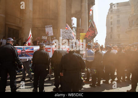 Londres, Royaume-Uni. 24 août 2019. Les participants de la police contiennent des partisans de Tommy Robinson sur les marches de l'Église toutes les âmes, sur le Langham Place près de Oxford Circus. Crédit : Joe Keurig / Alamy News Banque D'Images