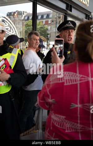 Londres, Royaume-Uni. 24 août 2019. La police arrête un partisan de Tommy Robinson, filmé par un autre manifestant lors de leur manifestation sur le Langham Place près de Oxford Circus. Crédit : Joe Keurig / Alamy News Banque D'Images