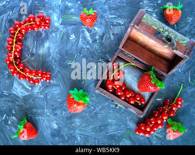 Fruits rouges sur fond gris. Groseille et fraise.Mix de baies dans boîte en bois.healthy lifestyle concept. La vitamine C alphabet.Prévention de la grippe Banque D'Images