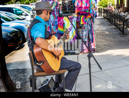 ASHEVILLE, NC, USA-10 le 18 juin : un artiste de rue chante et joue de la guitare, tandis que les clients à dîner à l'extérieur du Carmel Cuisine et Bar. Banque D'Images