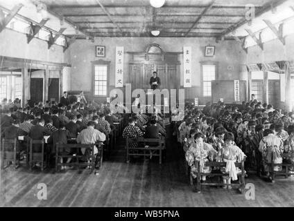 [ 1930 - Japon ] Les élèves de l'école élémentaire Japonais - Japonais les enfants de l'école primaire et leurs enseignants dans le hall de l'école. c1920s ou 1930. 20e siècle Tirage argentique d'époque. Banque D'Images