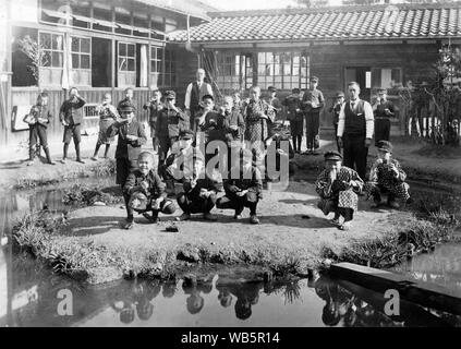 [ 1930 - Japon ] Les élèves de l'école primaire japonaise - mâle japonais les enfants de l'école primaire et leurs enseignants dans la cour de l'école. c1920s ou 1930. 20e siècle Tirage argentique d'époque. Banque D'Images