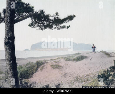 [ 1890 ] l'île d'Enoshima - Japon - L'île de Enoshima dans la baie de Sagami, préfecture de Kanagawa vu depuis les dunes sur la côte. Une portée de sable s'étendant de la plage de l'île peut être vu à gauche de l'homme avec son dos à la caméra. La petite île avec une circonférence de 4 km a été reliée au continent à marée basse, mais ne peut être atteint par bateau à marée haute. 19e siècle vintage albumen photo. Banque D'Images