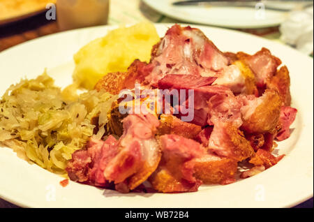 Porc aux légumes frits allemand sur une plaque blanche Banque D'Images