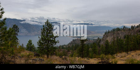 Vue panoramique de la ville de Penticton lors d'un ciel nuageux et smokey matin d'été. Prises dans le parc provincial Skaha Bluffs, British Columbia, Canada. Banque D'Images