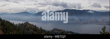 Vue panoramique de la ville de Penticton lors d'un ciel nuageux et smokey matin d'été. Prises dans le parc provincial Skaha Bluffs, British Columbia, Canada. Banque D'Images