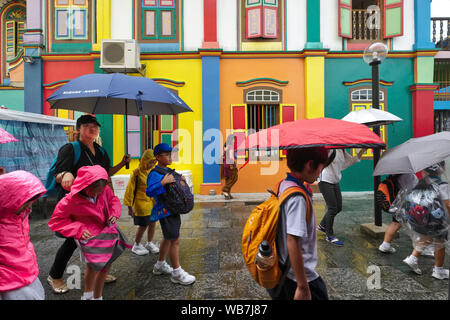 Lors de fortes pluies, de l'école passent les enfants la maison de Tan Teng, l'INAH villa colorée d'un ancien entrepreneur chinois, Little India, Singapour Banque D'Images