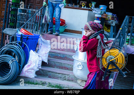 Shimla, Himachal Pradesh, Inde - Juillet 20th, 2019 : Indian Women walking on street.de soulever des poids lourds rouleaux de câble électrique sur sa tête. Banque D'Images