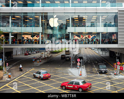 Les taxis rouges en passant par l'Apple Store en Europe centrale. Hong Kong, Chine. Banque D'Images