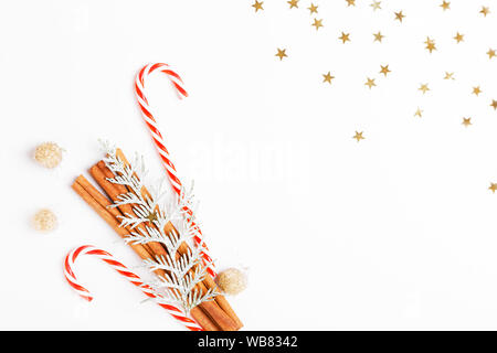 Composition de Noël. Arbre de Noël de branches de conifères, boules rouges, décorations d'or sur fond blanc. Banque D'Images