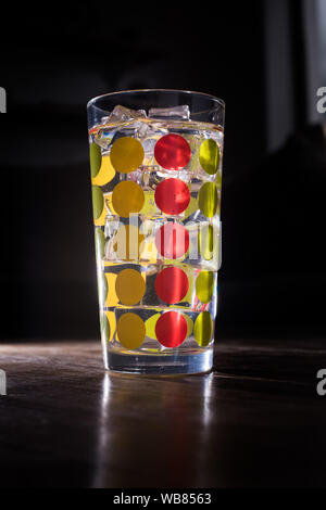 Colourfull grand verre rempli de limonade glacée isolé sur fond sombre Banque D'Images