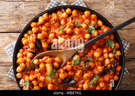 Plat de ragoût de pois chiches aux aubergines, tomates, oignons, herbes et épices gros plan sur une assiette sur la table. Haut horizontale Vue de dessus Banque D'Images
