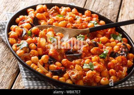 Moyen-orientale épicée nourriture de pois chiches aux aubergines, tomates, oignons, herbes et épices libre sur une plaque sur la table horizontale. Banque D'Images