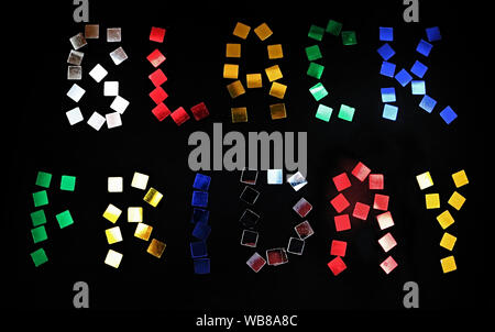 Les mots Vendredi Noir est aménagé de confettis de couleurs sur fond noir. Concept vente vendredi noir Banque D'Images