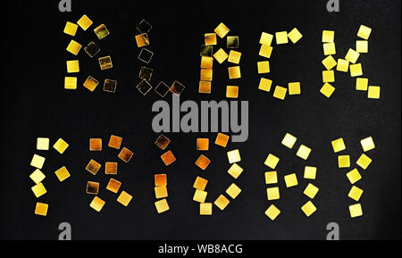 Les mots Vendredi Noir est aménagé de confettis d'or sur fond noir. Concept vente vendredi noir Banque D'Images