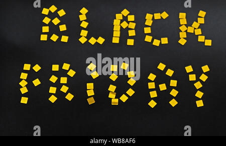 Les mots Vendredi Noir est aménagé de confettis d'or sur fond noir. Concept vente vendredi noir Banque D'Images