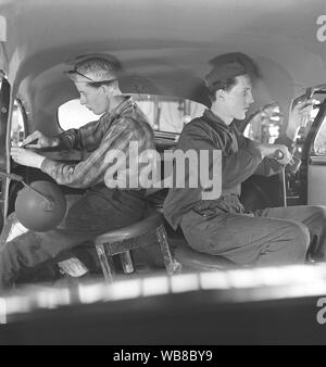 La production des automobiles dans les années 40. Un intérieur d'une voiture en cours de fabrication. Deux hommes se monte le toit intérieur tissu textile. Après la seconde guerre mondiale, plusieurs sociétés en Suède a reçu des voitures en pièces détachées et assemblée. C'était moins cher d'importer des pièces de voiture puis l'ensemble de la voiture. Suède 1948. Kristoffersson ref AP91-3 Banque D'Images