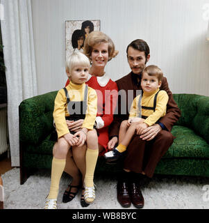 1960 parents. Une mère et son père sont assis ensemble avec leurs enfants dans un canapé vert. Suède 1969 Banque D'Images