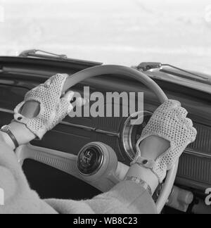 La conduite dans les années 1960. Une femme témoigne d'une nouvelle paire de gants destinés à être utilisés lors de la conduite. Suède 1962 Banque D'Images