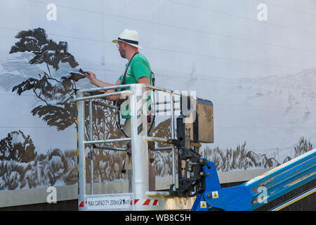 Bournemouth, Dorset UK. 25 août 2019. L'artiste britannique David Downes a été commandé par ITV pour créer une murale de grande envergure pour lancer leur nouveau drame Sanditon, basé sur le roman inachevé par Jane Austen. La peinture murale de la ville fictive de Sanditon sera de 12 mètres de large et est peinte sur 5 jours à partir d'aujourd'hui avant le premier épisode de Sanditon à la télévision ce soir, la murale sera ensuite sur l'écran pendant 3 semaines. Credit : Carolyn Jenkins/Alamy Live News Banque D'Images