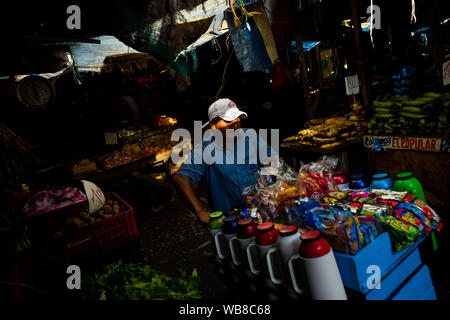 Un vendeur de rue, pousse une charrette, chargé avec thermos remplie de café et des sucreries, dans le marché d'Bazurto à Cartagena, Colombie. Banque D'Images