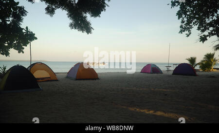 Camp avec des tentes sur la plage au lever du soleil. Camp avec les touristes sur une île tropicale. L'été et les vacances Banque D'Images