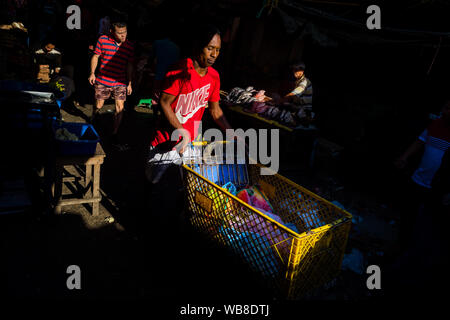 Un transporteur d'Afro-Colombiens pousse un chariot de supermarché sur mesure, chargé avec les biens achetés, dans le marché d'Bazurto à Cartagena, Colombie. Banque D'Images