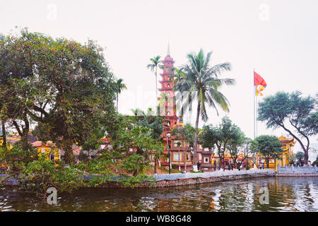 La pagode Tran Quoc et vietnamiens drapeau sur le lac de l'ouest de Hanoi, capitale du Vietnam en Asie du sud-est. L'architecture de temple tour traditionnelle pour les vietnamiens Banque D'Images