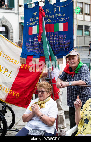 Fivizzano, Italie. 25 août 2019. Lors de la cérémonie de commémoration pour les victimes de l'Fivizzano massacres, les spectateurs suivent le discours du président, M. Steinmeier, en italien. Dans la phase finale de la Seconde Guerre mondiale, des soldats de la Wehrmacht et SS tué plusieurs milliers de civils en Italie. Il y a 75 ans, dans la région autour de Fivizzano dans le nord de la Toscane seulement, près de 400 hommes, femmes, vieillards et d'enfants ont été assassinés par les Allemands, souvent dans une façon incroyablement cruels, à un massacre qui a duré plusieurs jours. Président fédéral Steinmeier et sa femme prennent part à la cérémonie de commémoration annuelle Banque D'Images