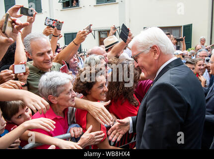 Fivizzano, Italie. 25 août 2019. Président fédéral Frank-Walter Steinmeier accueille les visiteurs à un événement commémoratif pour les victimes des massacres à Fivizzano. Dans la phase finale de la Seconde Guerre mondiale, des soldats de la Wehrmacht et SS tué plusieurs milliers de civils en Italie. Il y a 75 ans, dans la région autour de Fivizzano dans le nord de la Toscane seulement, près de 400 hommes, femmes, vieillards et d'enfants ont été assassinés par les Allemands, souvent dans une façon incroyablement cruels, à un massacre qui a duré plusieurs jours. Président fédéral Steinmeier et sa femme prennent part à la cérémonie de commémoration annuelle de la Banque D'Images