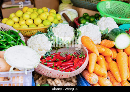 Assortiment de légumes asiatiques tels que les choux-fleurs, chou, carotte, poivron, citron sur l'affichage à Hoi An au Vietnam en Asie. La rue du marché vietnamien avec Banque D'Images