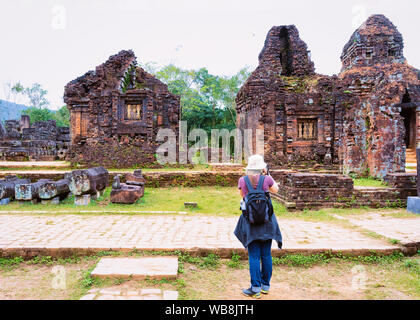 Sac à dos fille avec prise de photos sur l'appareil-photo au sanctuaire de My Son et Temple Hindou près de Hoi An au Vietnam en Asie. Patrimoine de royaume de Champa. Myson Hist Banque D'Images