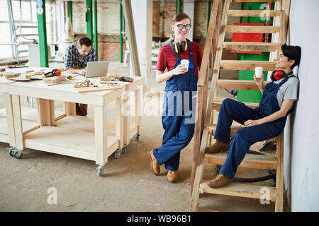 Portrait de deux jeunes travailleurs se reposer et boire du café pendant les pauses dans l'atelier, copy space Banque D'Images