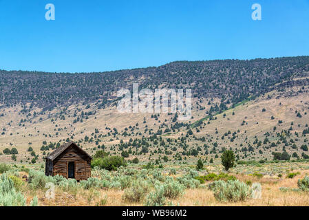 Cabane abandonnée dans le sud-est de l'Oregon avec le Steens Mountain Range dans l'arrière-plan Banque D'Images