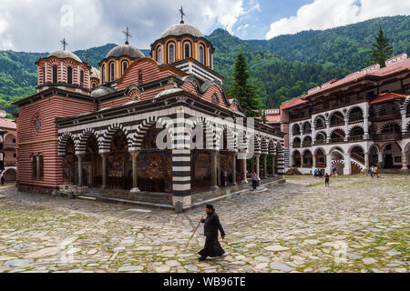 Moine orthodoxe de marcher à travers la cour intérieure au monastère de Saint Ivan de Rila, mieux connu comme le Monastère de Rila en Bulgarie Banque D'Images