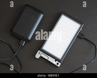 La source de lumière RVB compact portable est facturé par portable en charge. Banque D'Images