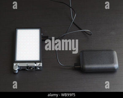 La source de lumière RVB compact portable est facturé par portable en charge. Banque D'Images