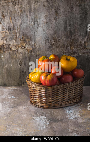 Heirloom mûrs tomates dans le panier, copiez l'espace. Banque D'Images